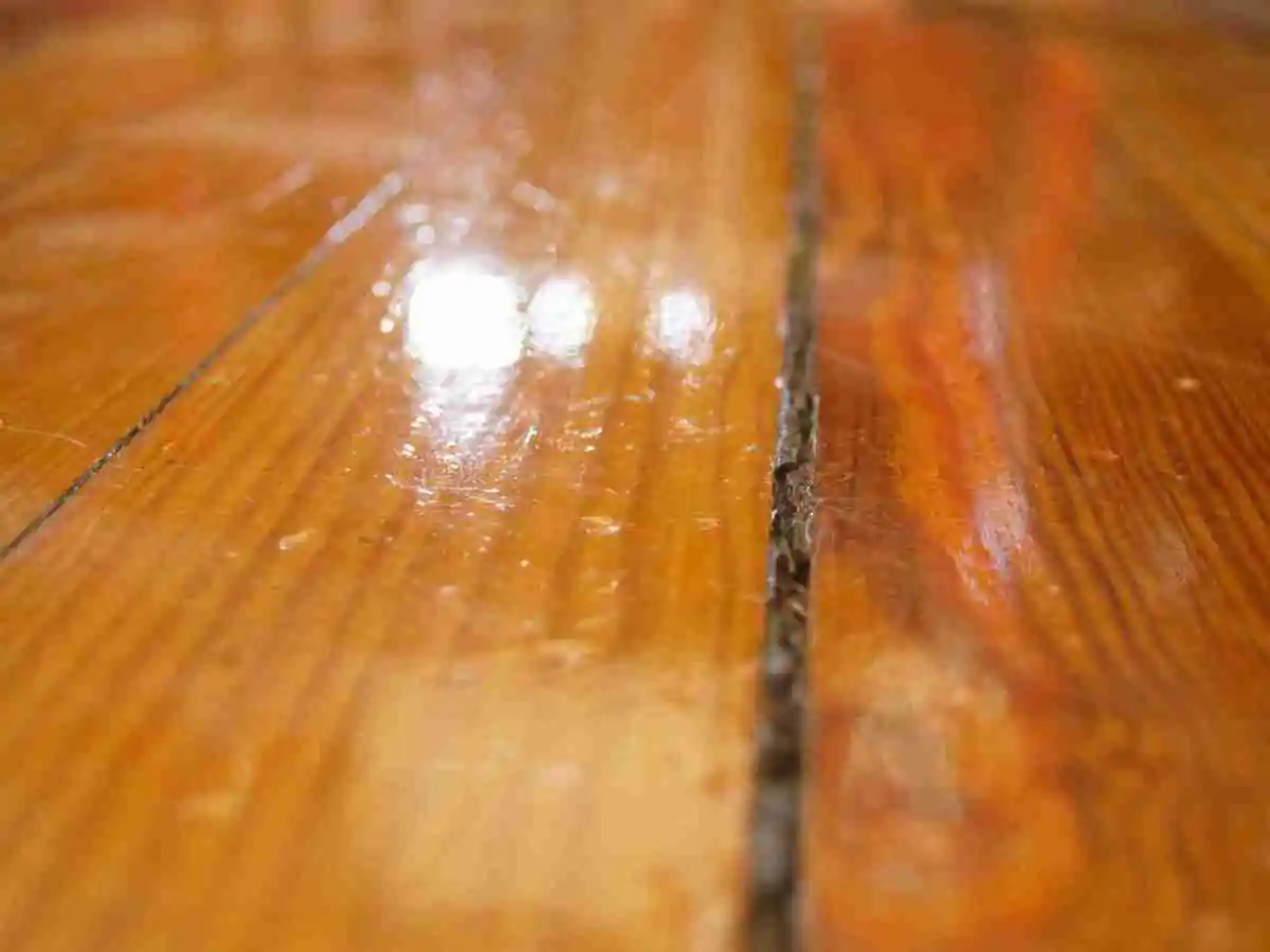Grietas abiertas en tarima de madera antes de decidir si acuchillar o reparar
