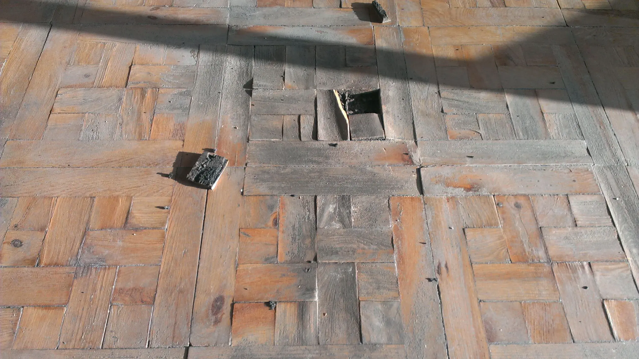 Parquet hidraulico con brea deteriorado por humedad y sol
