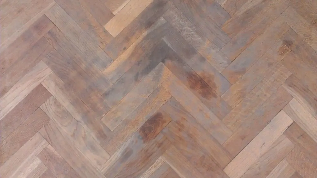 Parquet de roble en espiga con manchas de grasa y barniz antiguo