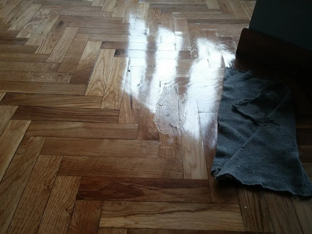Huella de calzado sobre barniz fresco en parquet de roble
