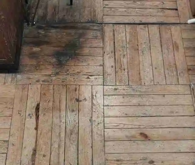 Parquet quemado por productos quimicos con manchas negras profundas