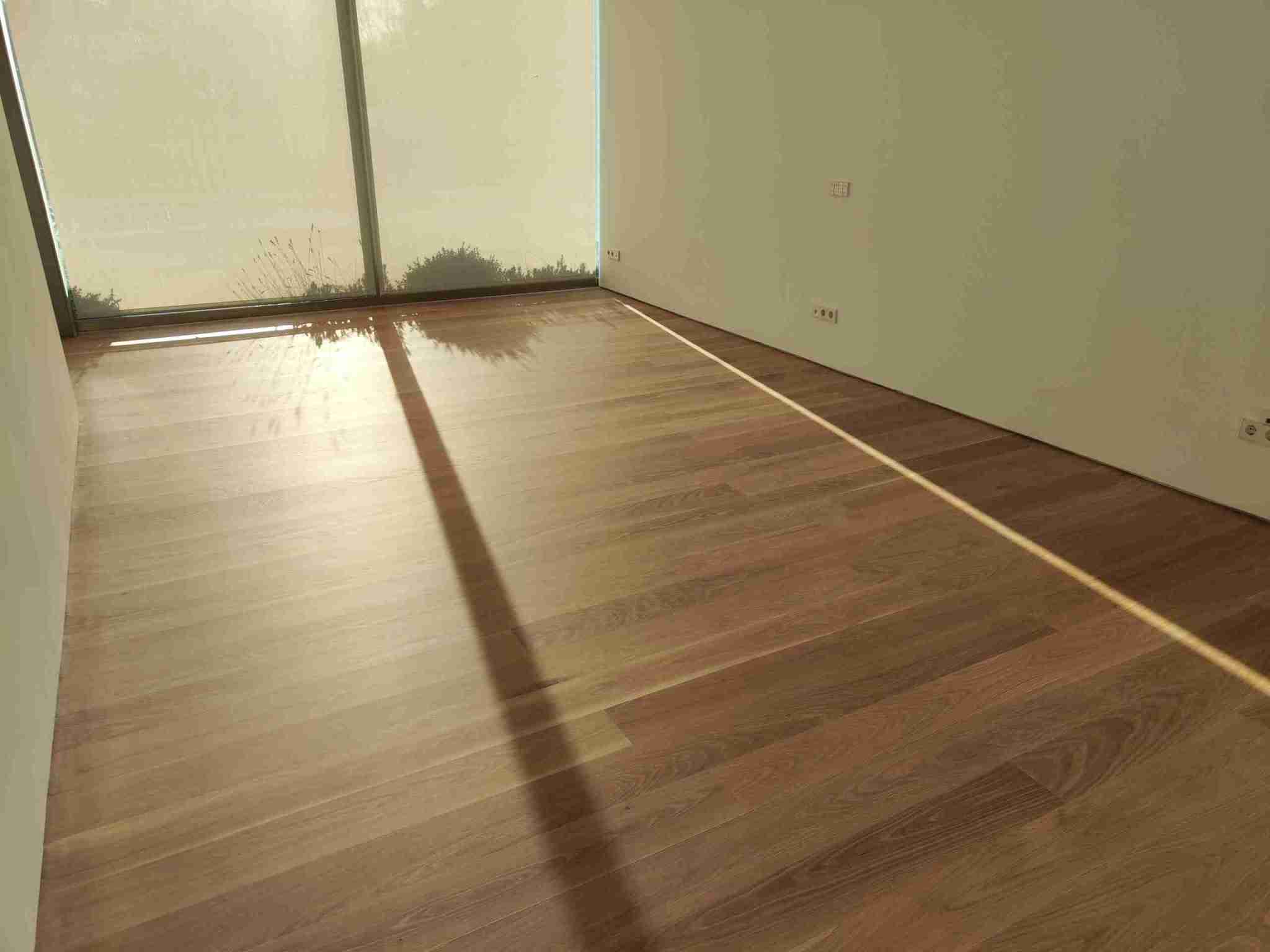 Suelo continuo de roble macizo restaurado y barnizado con Deva Plus Transit Natur en vivienda de Pozuelo.