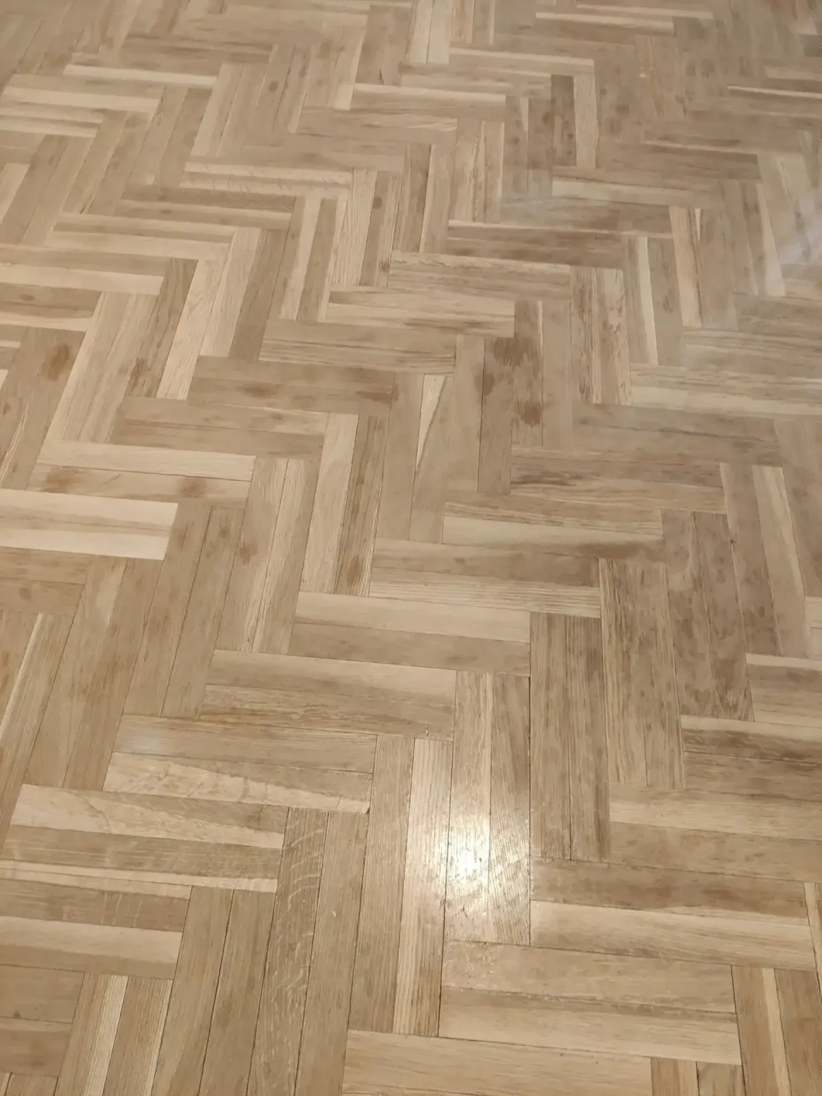 Superficie de parquet con manchas de acabado asociado a barniz Urea Formol
