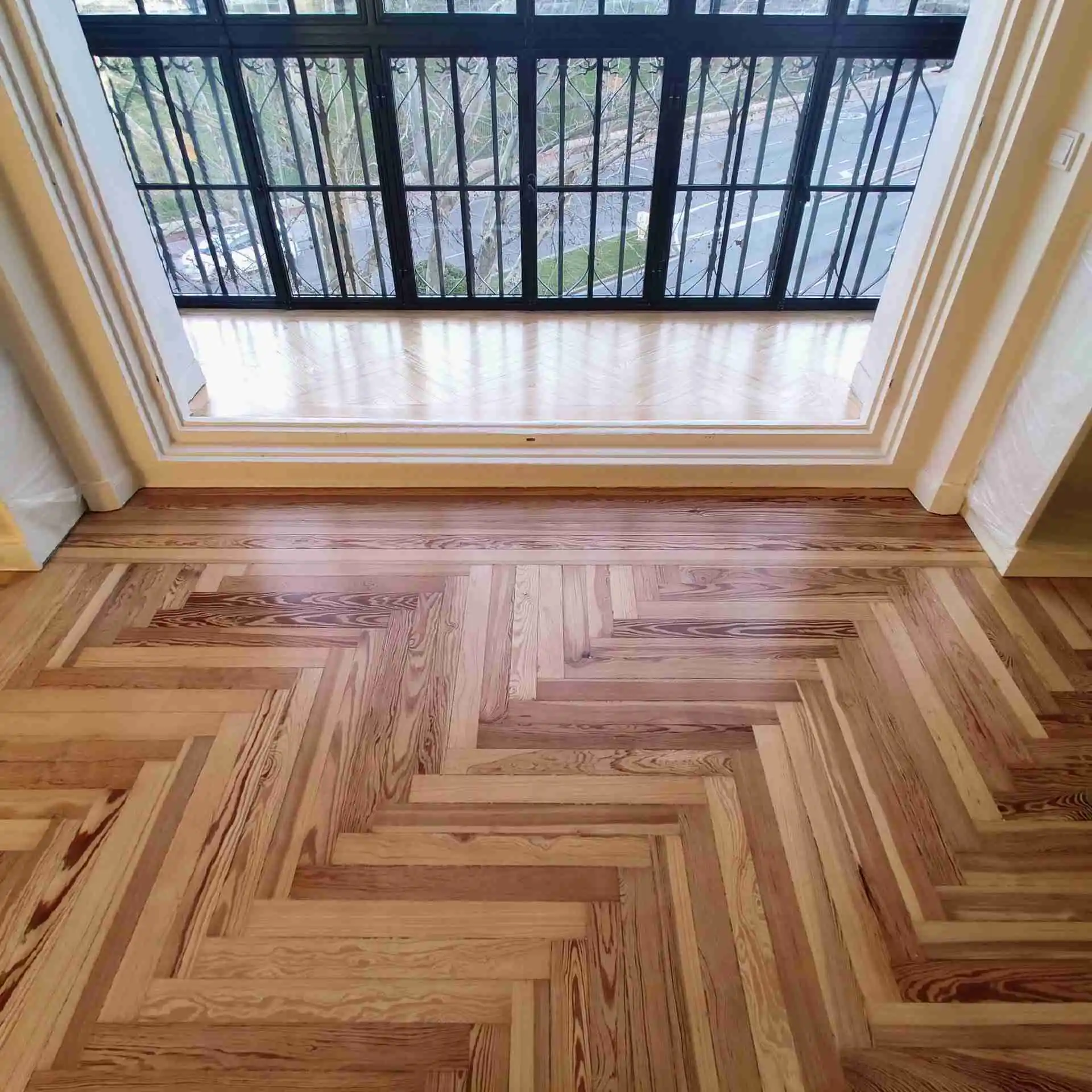 Salón con tarima de pino melis viejo en Jerónimos Salón con parquet de pino melis viejo restaurado en Montalbán, Madrid