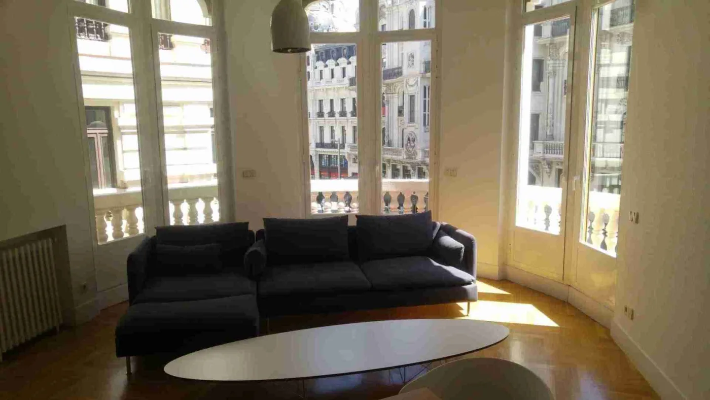 Sala con sofas junto a ventanales y parquet antes de planificar el acuchillado