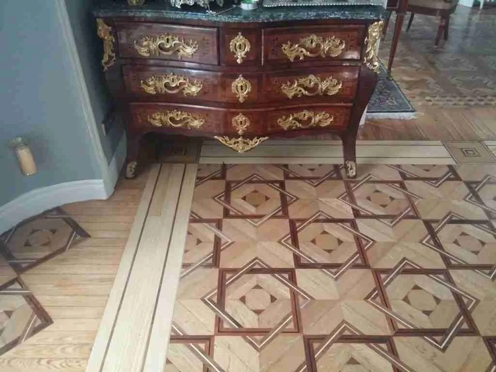 Mueble pesado sobre parquet de marqueteria que condiciona la restauracion