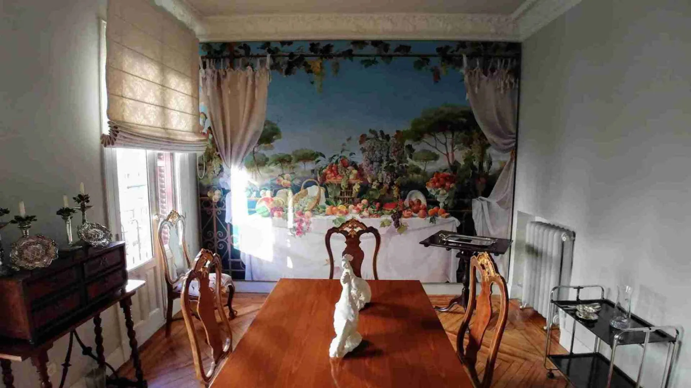 Comedor con mural y muebles delicados sobre parquet antes de restaurar