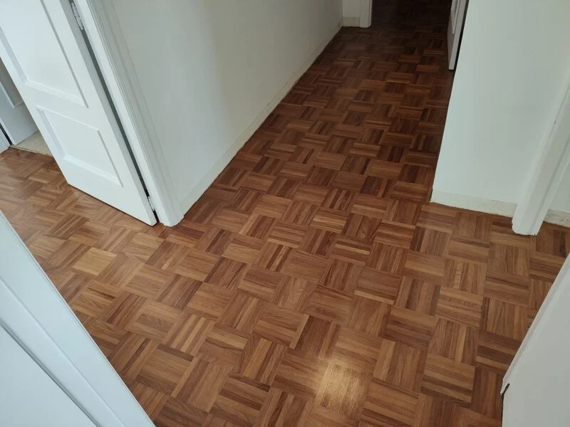 Pasillo con parquet de diseño geométrico restaurado por Parquets da Cruz