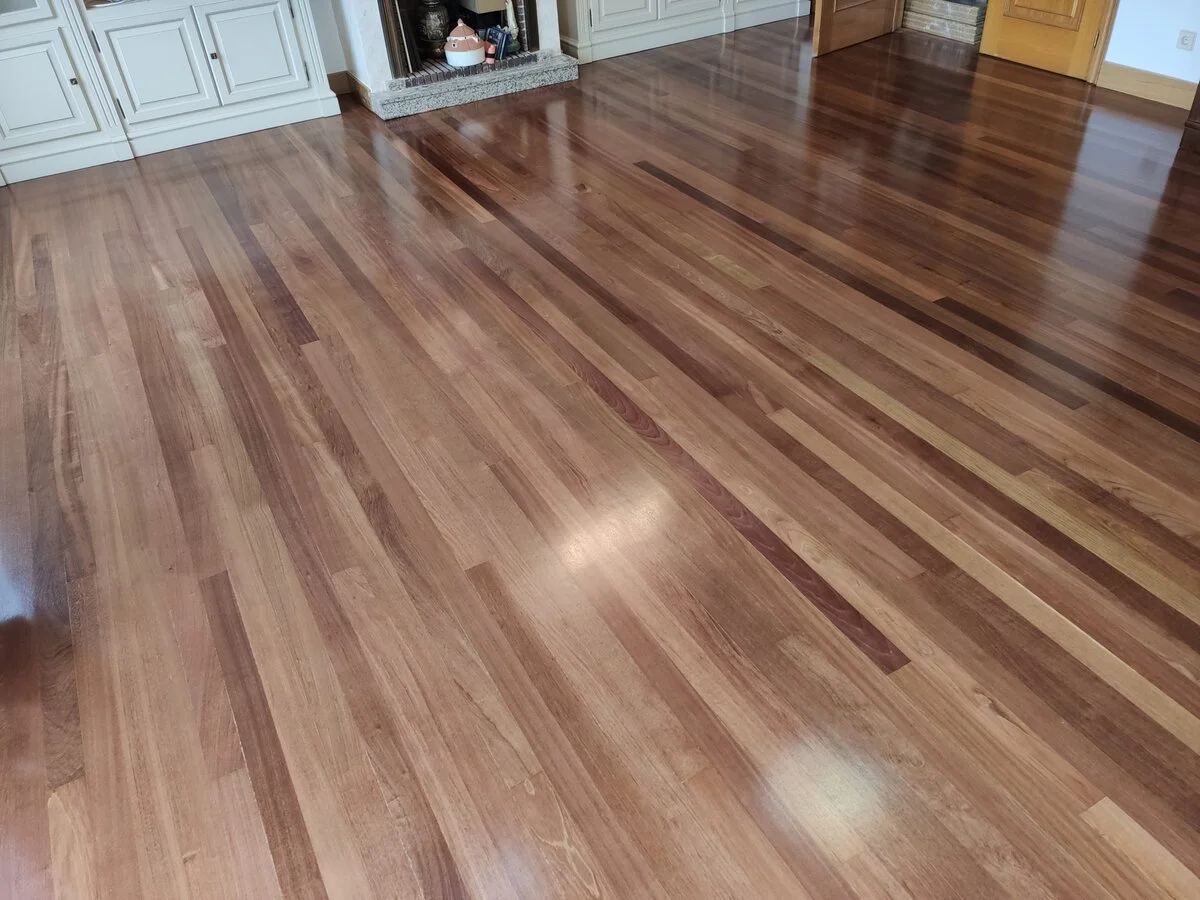 Salón con chimenea y parquet de madera oscura barnizada por Parquets da Cruz en Valladolid