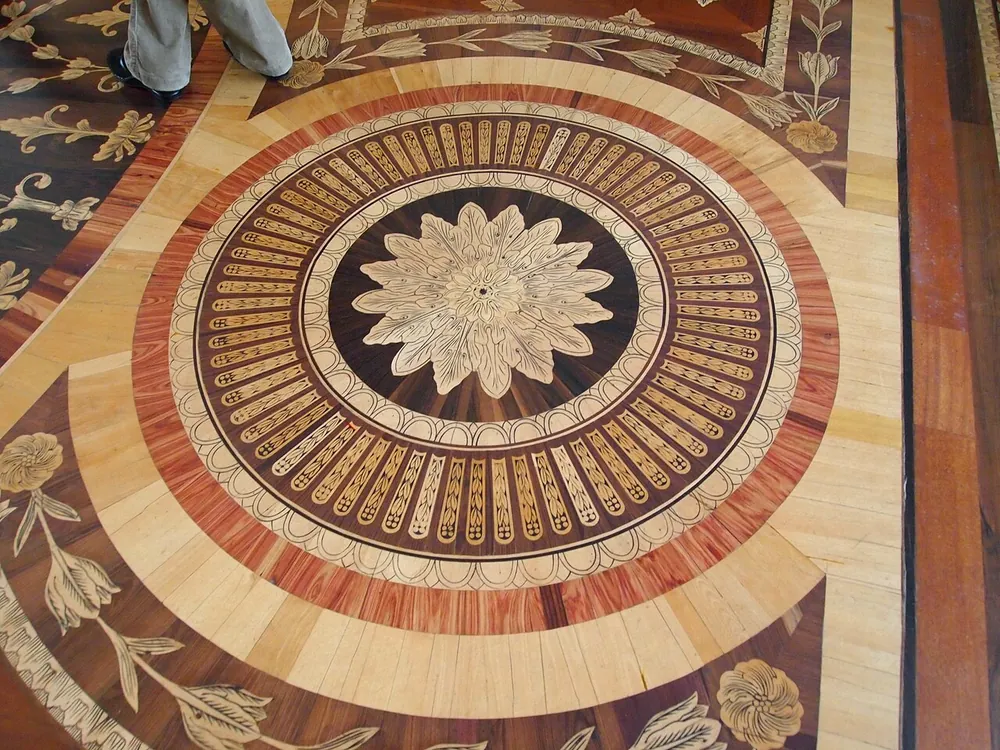 Medallón de taracea con roseta central y tulipanes en el parquet de la Sala de Apolo