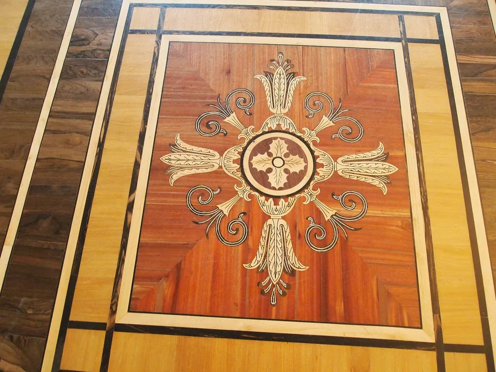 Panel de caoba con una cruz de volutas y flores de marquetería en la Sala Malaquita