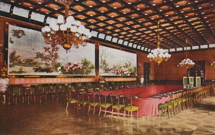 Postal coloreada de una sala con mesa larga y grandes pinturas, sobre un suelo claro de rombos