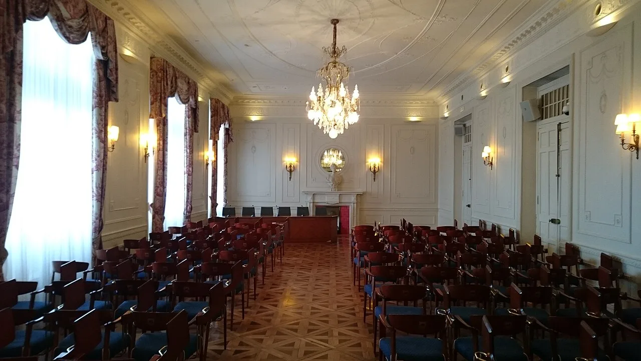 Salón de Baile con filas de sillas a ambos lados de un pasillo de parquet de paños con diagonales
