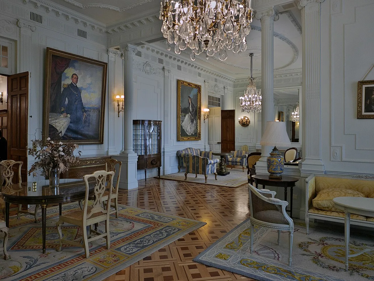 Salón de Familia con alfombras, retratos y parquet claro de paños con cuadrados oscuros en diagonal