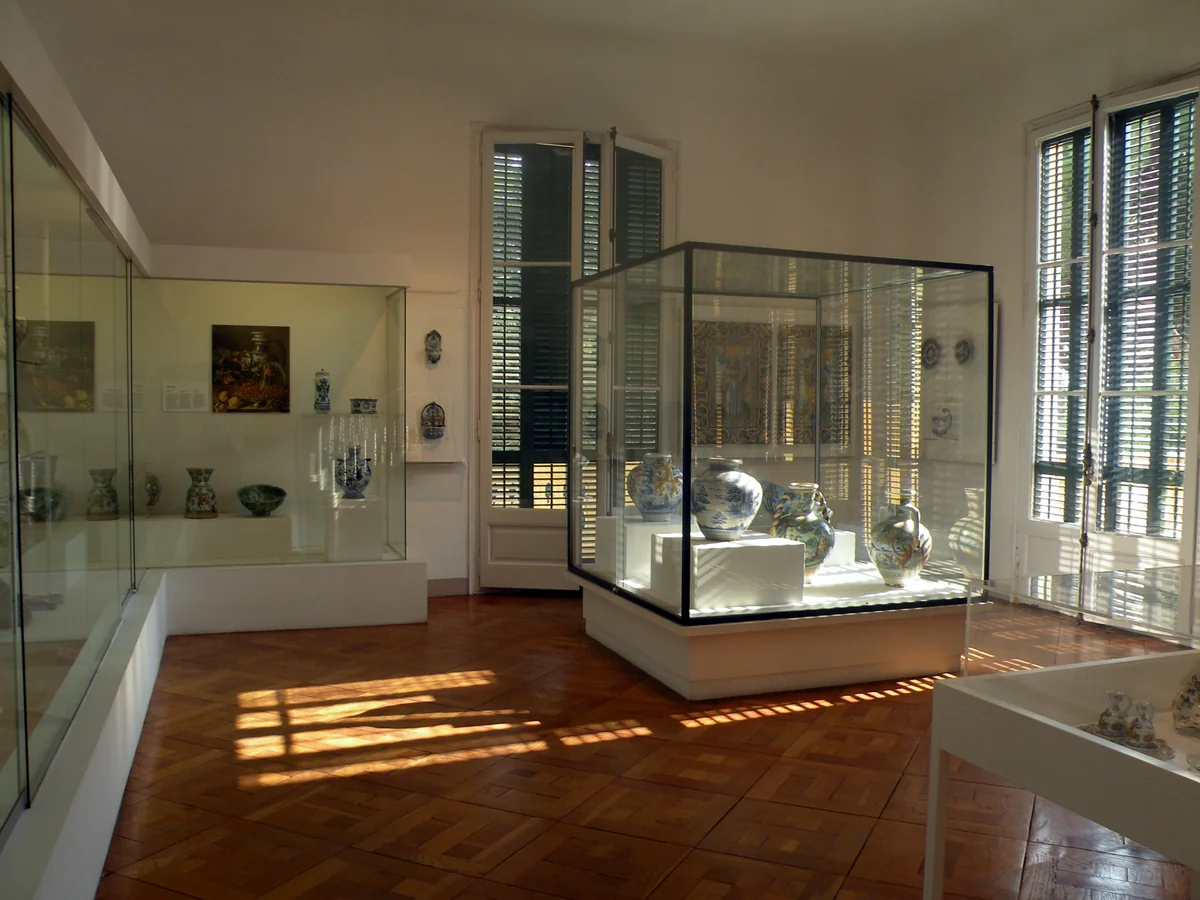 Sala del antiguo Museo de Cerámica en el Palacio Real de Pedralbes con vitrinas y parqué de cuadros de tablillas en damero