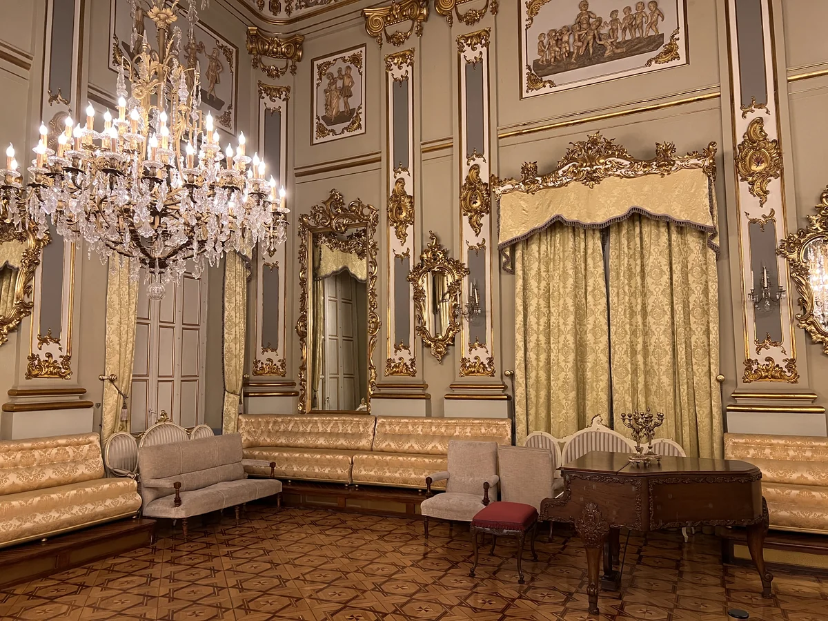 Salón de Baile con sofás tapizados, sillas y un piano sobre la pista de madera taraceada